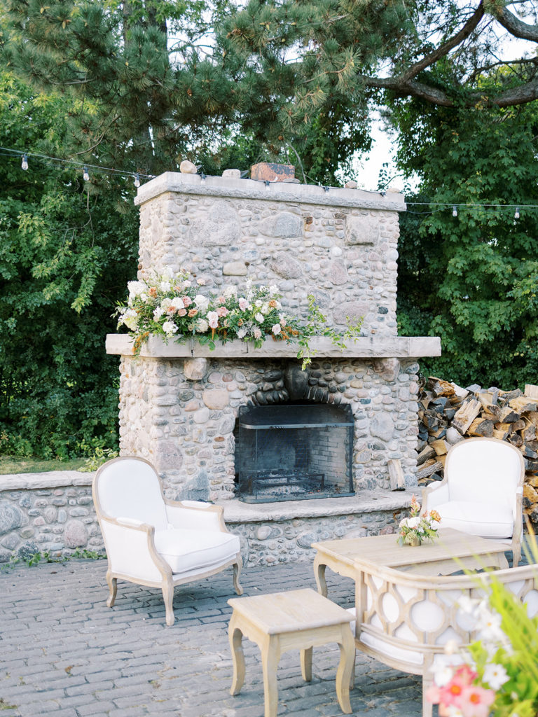 large stone fireplace with green white and copper flowers on the mantel 