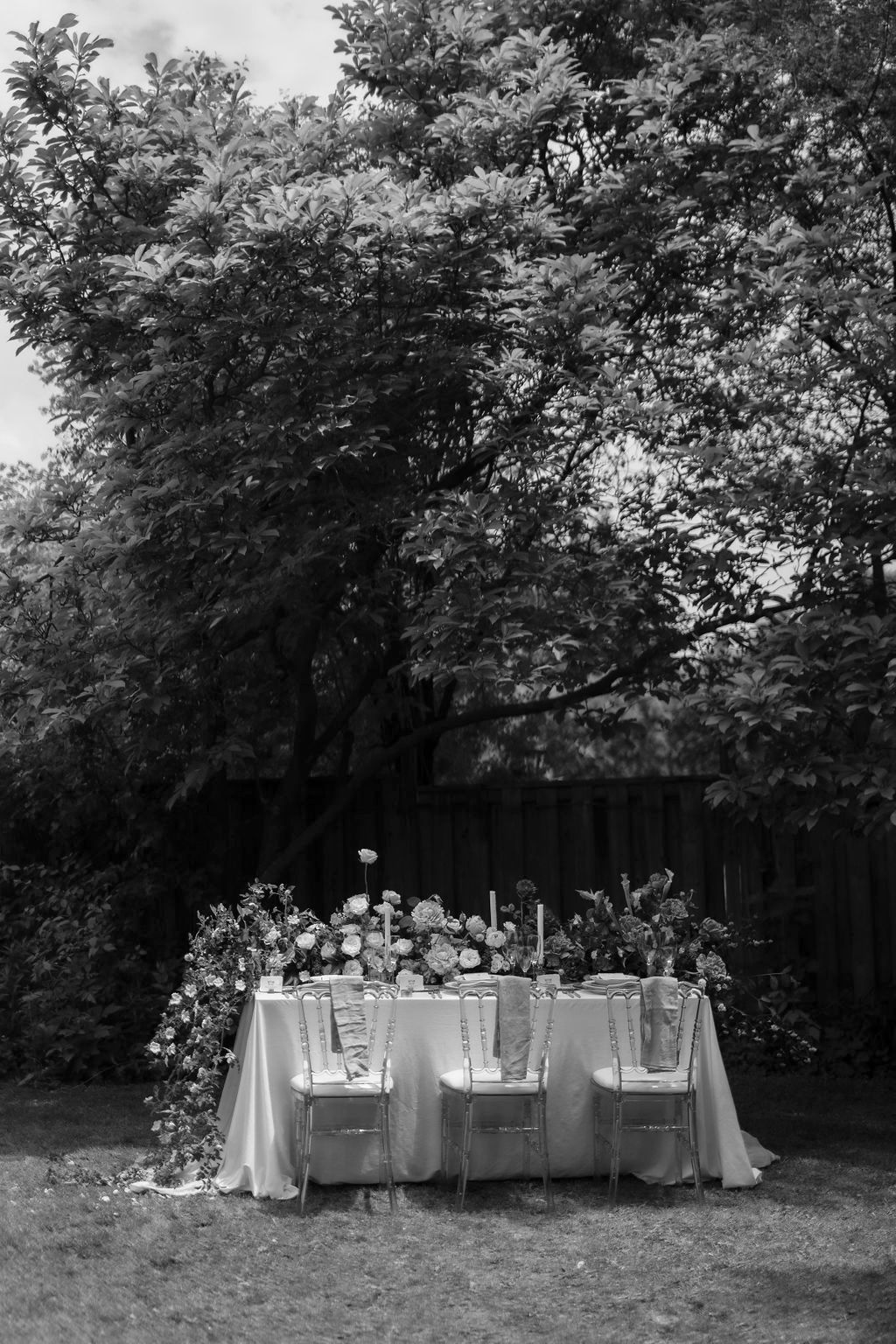 black and white picture of lush florals on a head table